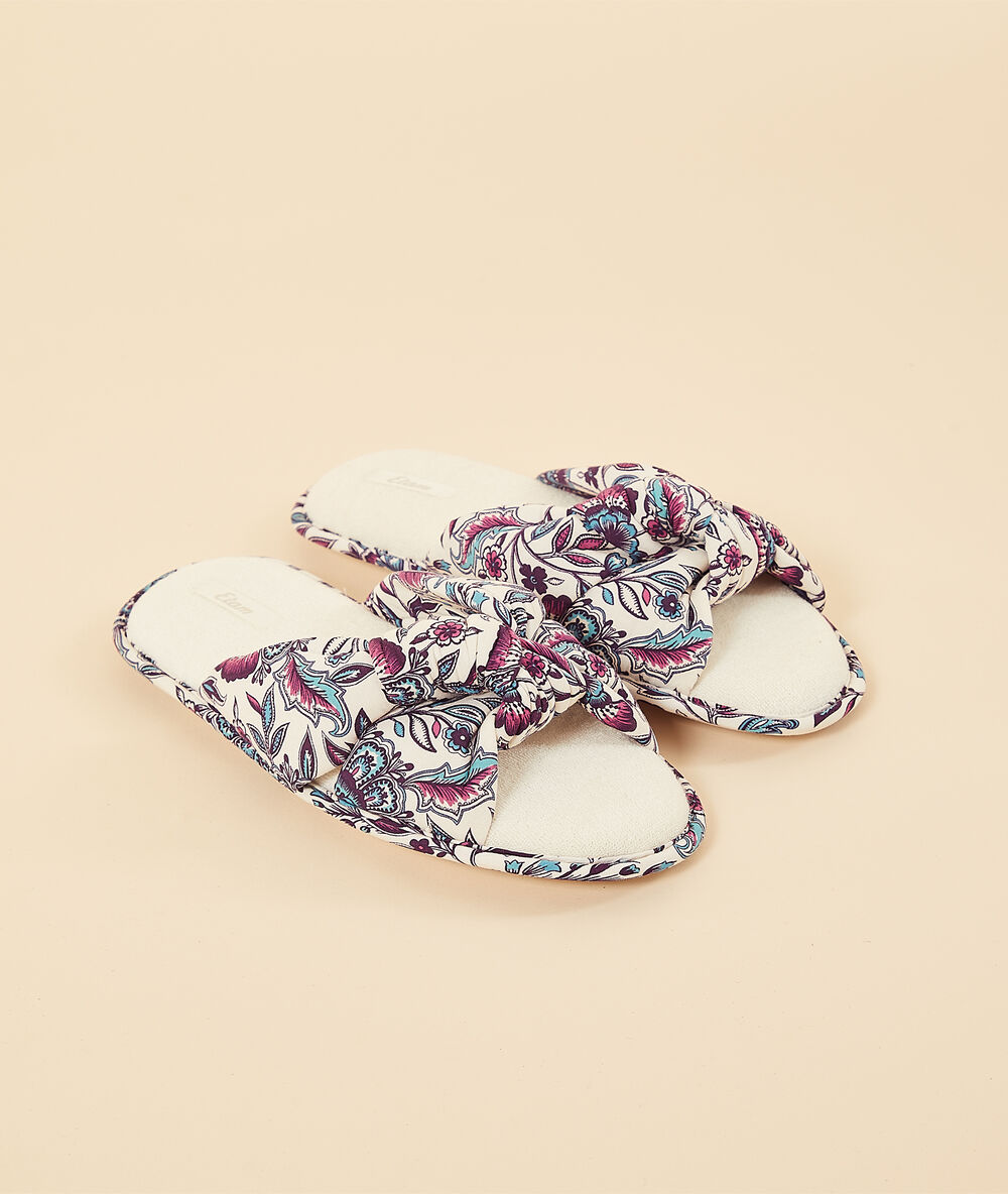 Zapatillas tipo chancla con nudo violeta.