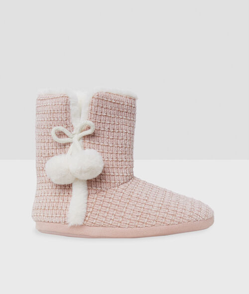 Zapatillas tipo botines con pompones rosa.