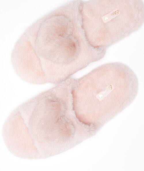 Zapatillas peluche con corazones rosa.