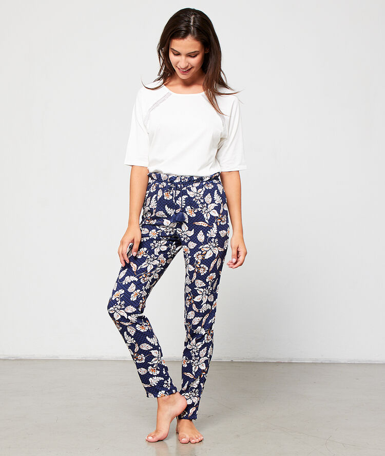 Pantalón estampado floral con pompones decorativos azul marino.