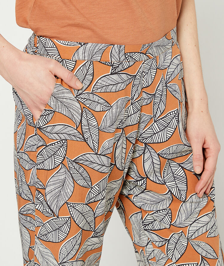 Pantalón estampado de hojas terracota.