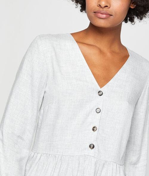 Blusa holgada con volante y botones frontales gris.