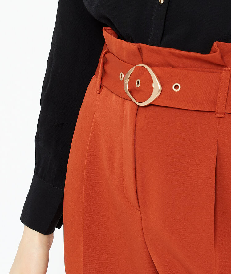 Pantalón talle alto con cinturón rojo.