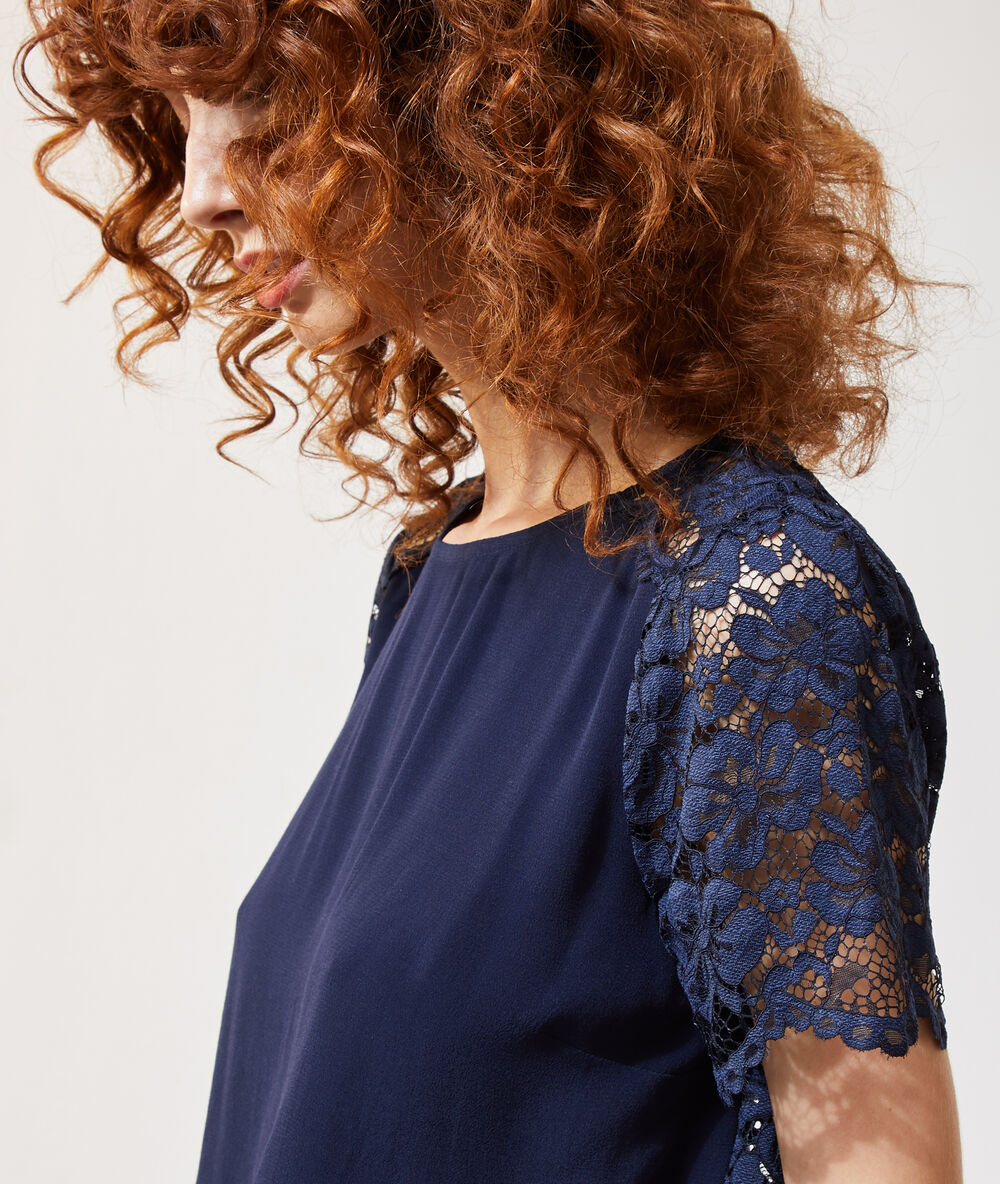 Blusa con mangas de encaje azul marino.