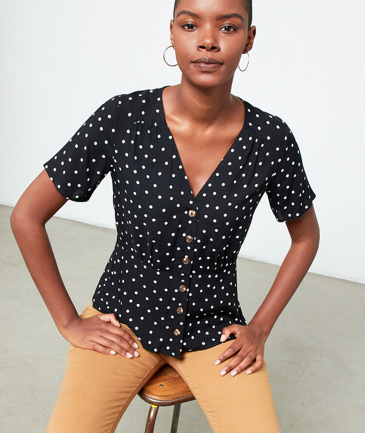 Blusa abotonada de lunares negro.