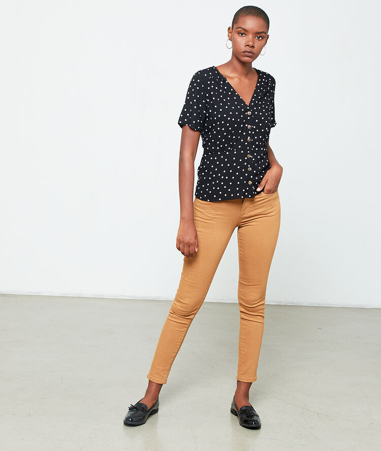 Blusa abotonada de lunares negro.