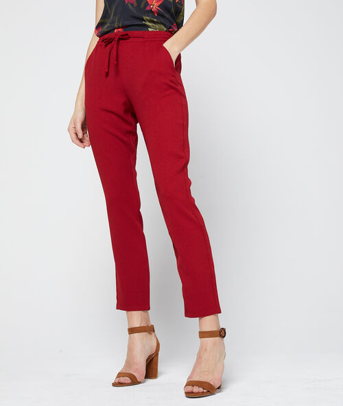 Pantal&oacute;n alto con cintur&oacute;n rojo.