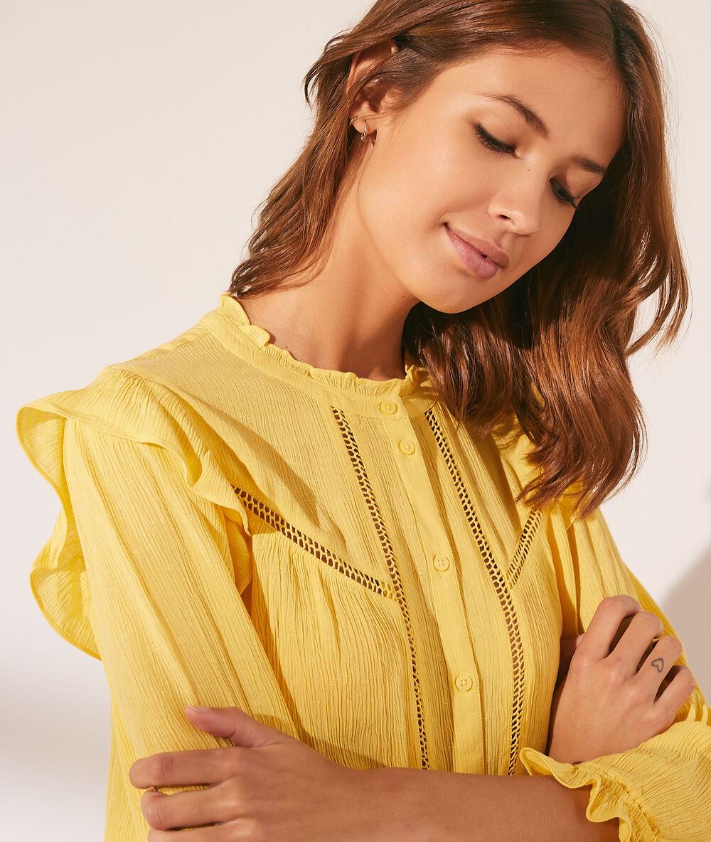 Camisa con volantes amarillo pálido.
