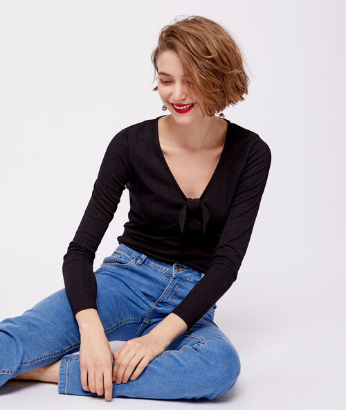 Camiseta escotada con lazo descorativo negro.
