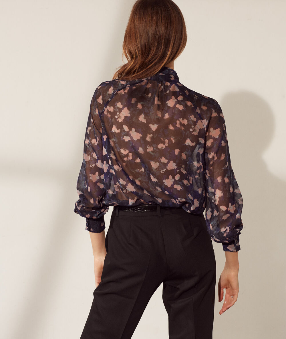 Blouse transparente col lavallière bleu marine.