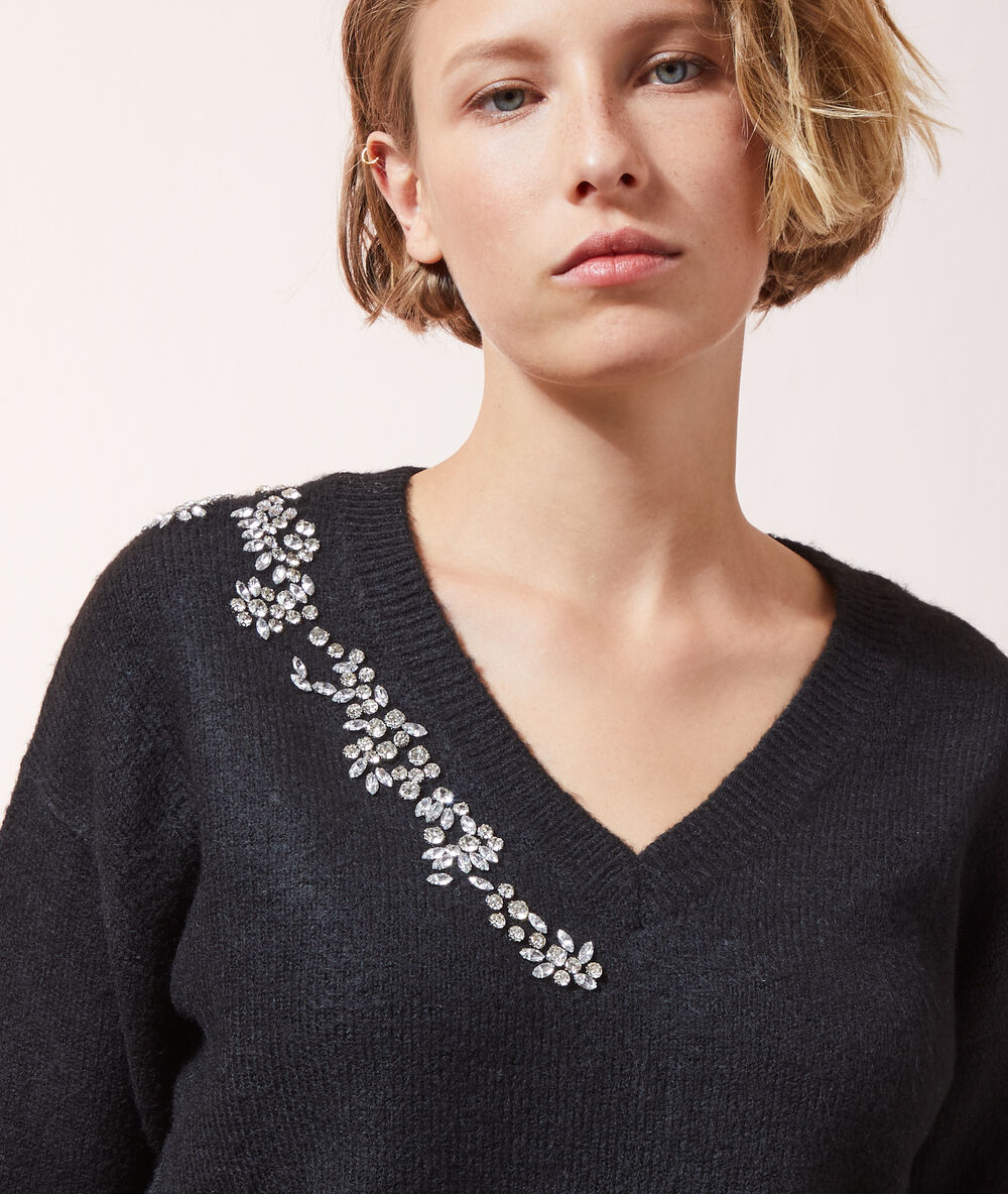 Pull en maille à strass noir.
