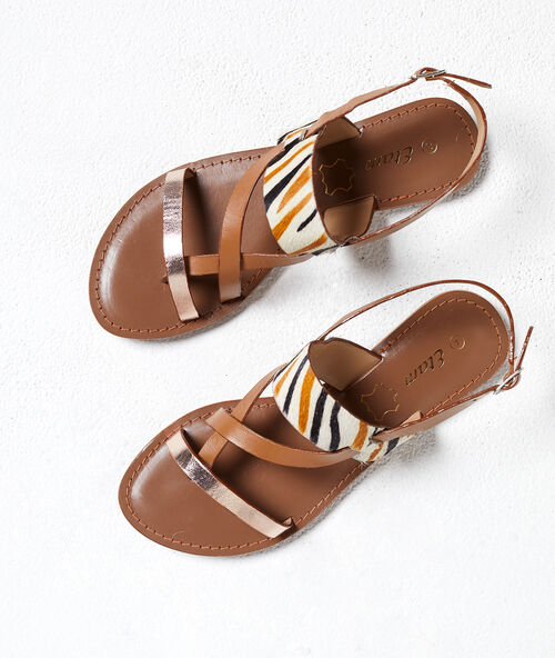 Sandalias planas con animal print naranja.