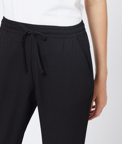 Pantalón alto con cinturón negro.