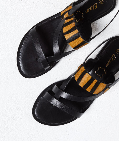 Sandalias planas con animal print negro.