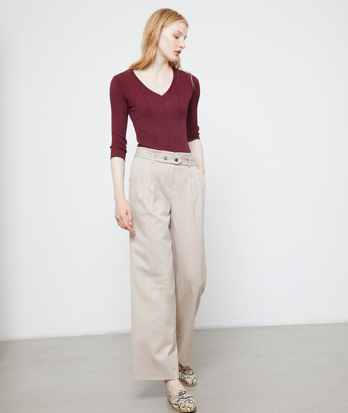 Pantalón ancho con cinturón crema.