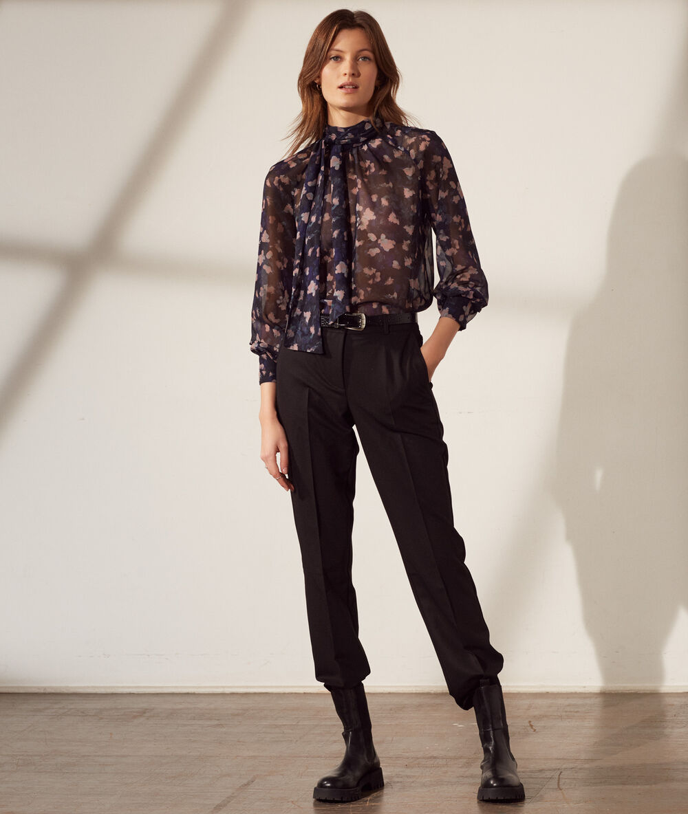 Blouse transparente col lavallière bleu marine.