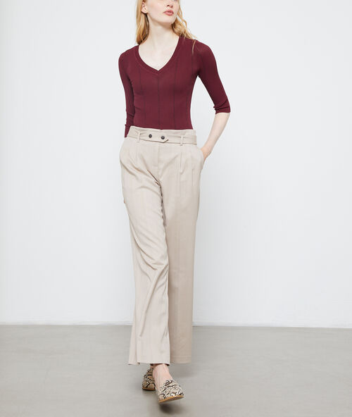 Pantalón ancho con cinturón crema.