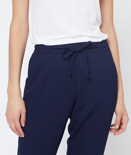 Pantalón alto con cinturón azul.