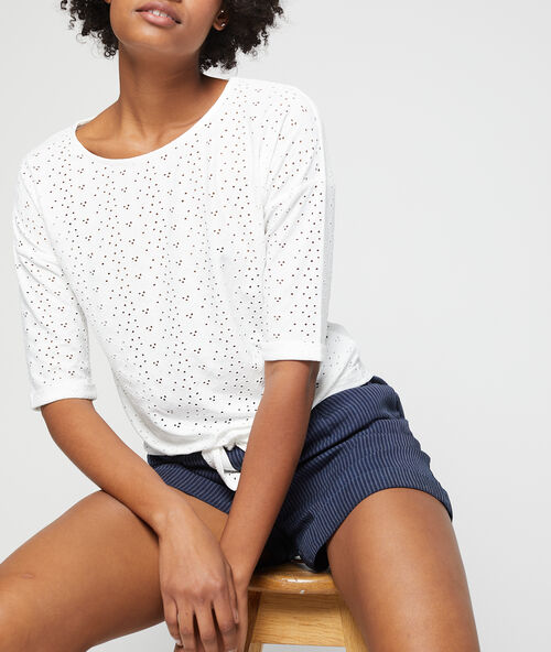 Camiseta anudada con encaje blanco.