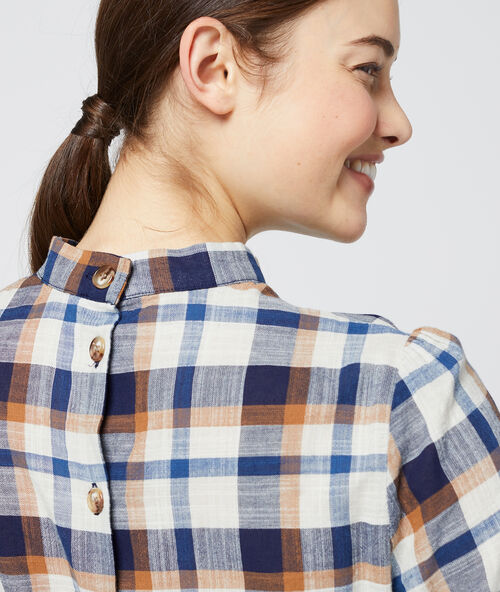 Blusa a cuadros con cuello anudado azul marino.