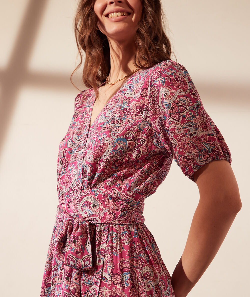Vestido largo con cinturón y estampado floral fucsia.