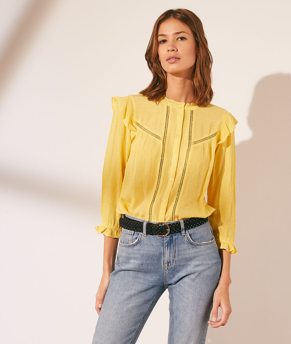 Camisa con volantes amarillo pálido.